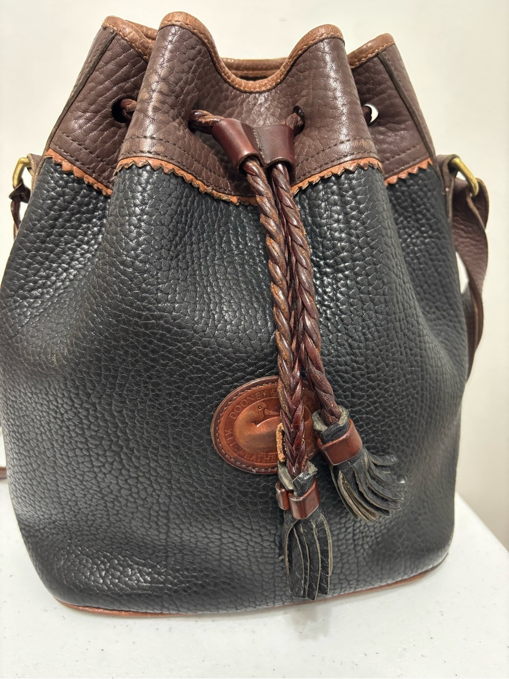 Dooney & Bourke Black Pebble Leather Drawstring Bucket Bag with Brown Trim